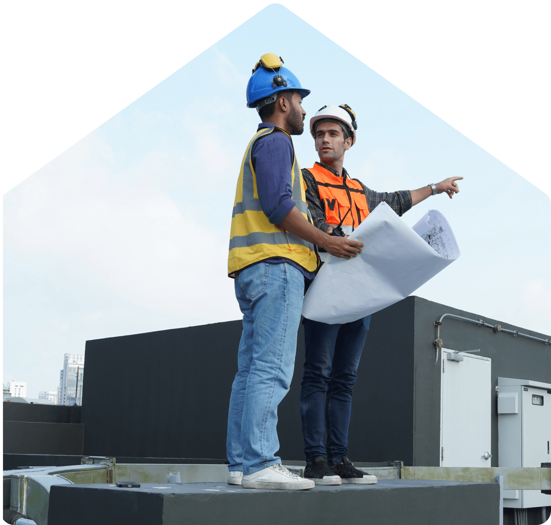 Dos ingenieros revisando planos sobre un techo comercial